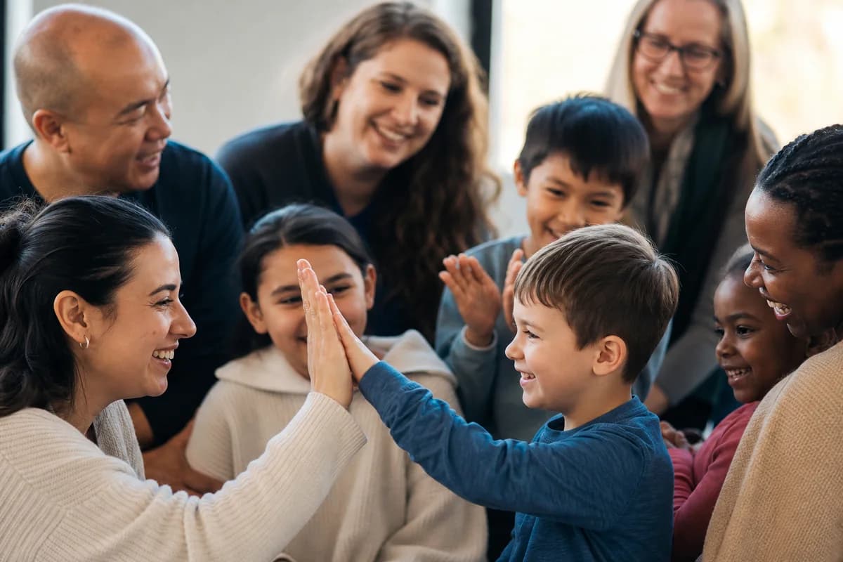 Families and autistic children celebrating a shared accomplishment at a support center